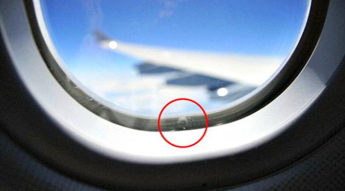 Jendela pesawat terbang memiliki 'lubang nafas' guna mengatur tekanan udara kabin pesawat. (Sumber Daily Mail)
