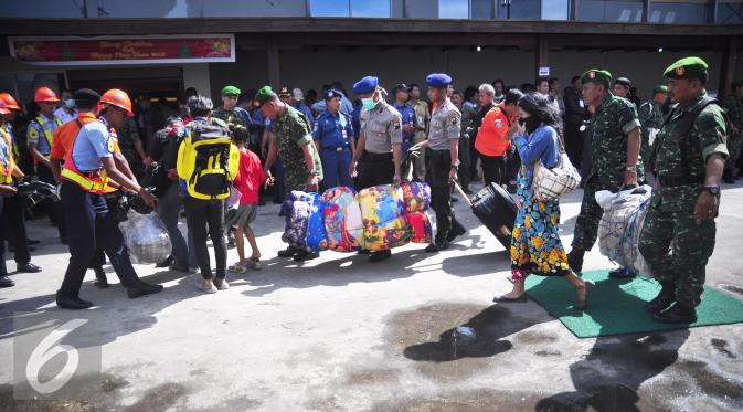 Sejumlah petugas membantu membawa barang mantan anggota Gafatar di Pelabuhan Tanjung Emas, Semarang , Senin (25/1). Manifest yang diangkut  kapal itu terdiri dari 128 kepala keluarga (KK) atau 359 jiwa. (Liputan6.com/Gholib)