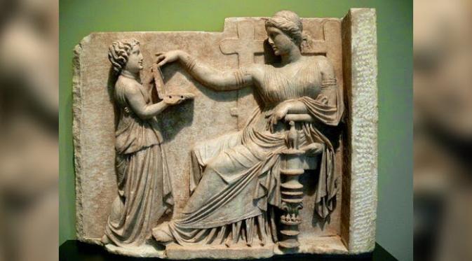 Sebuah patung dari Yunani kuno menggambarkan seorang wanita memegang alat yang sangat mirip dengan laptop di era modern.