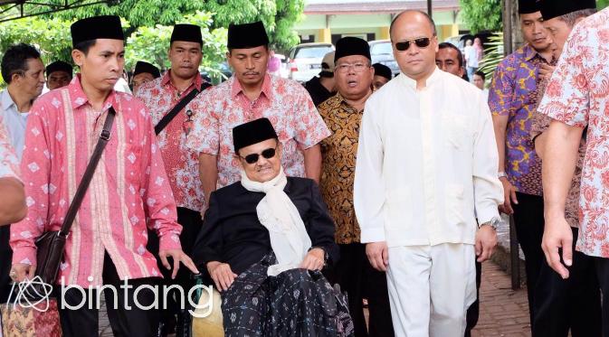 BJ Habinie dibantu kursi roda ke pemakaman kakak tercinta. (Desmon/Bintang.com)