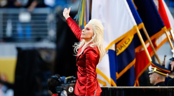Penampilan Lady Gaga sebelum dimulainya NFL Super Bowl 50 antara Panthers Carolina dan Denver Broncos di Santa Clara, California, Minggu (7/2). Berbalut busana dari Gucci, Gaga itu tampil serba merah seperti bendera negaranya (Al Bello/Getty Images/AFP)