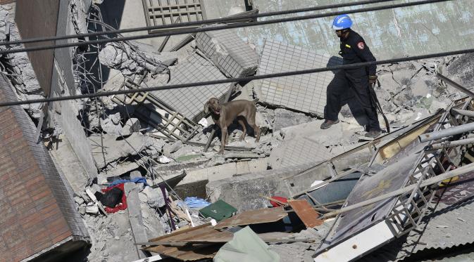 Tim penyelamat mencari korban di reruntuhan bangunan yang ambruk akibat gempa 6,4 SR di Tainan, Taiwan, Senin (8/2). Dua korban, Tsai Wei-ling dan Lee Tsung-tien, berhasil diselamatkan setelah terperangkap selama lebih dari 50 jam. (AFP PHOTO/Sam Yeh)