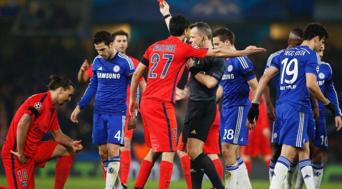 Wasit mengeluarkan kartu merah untuk Zlatan Ibrahimovic (kiri) setelah striker Paris Saint-Germain tersebut menekel keras gelandang Chelsea, Oscar. Pada Leg 2 Babak 16 Besar Liga Champions 2014-2015 tersebut, pertandingan berakhir imbang 2-2. PSG lolos ke