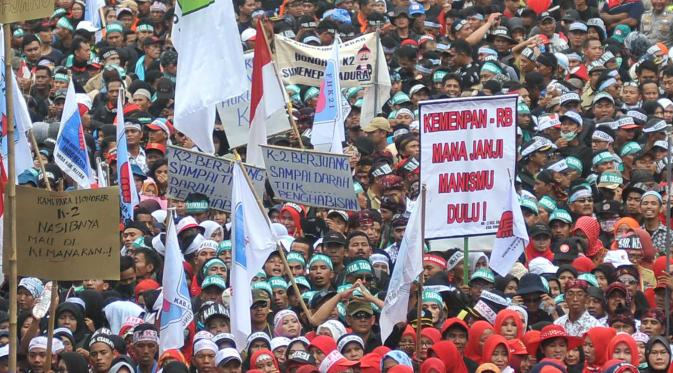 Massa dari Forum Honorer Kategori 2 (FHK2I) membawa berbagai atribut saat unjuk rasa di depan Istana Merdeka Jakarta, Rabu (10/2). Guru honorer dari seluruh Indonesia itu menuntut Pemerintah agar mengangkat mereka sebagai PNS (Liputan6.com/Gempur M Surya)