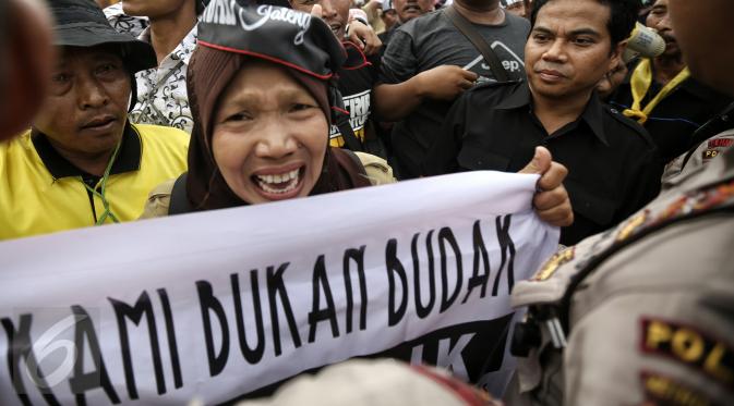 Ekspresi seorang pengunjuk rasa saat menyuarakan orasinya di depan Istana Merdeka, Jakarta, Rabu (10/2). Guru honorer dari seluruh Indonesia itu menuntut Pemerintah agar mengangkat mereka sebagai PNS (Liputan6.com/Faizal Fanani)