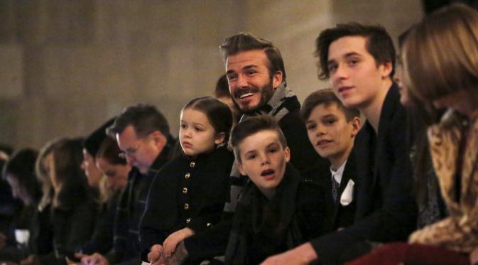 Mantan pesepakbola, David Beckham duduk di barisan depan bersama anak-anaknya Harper, Cruz, Romeo dan Brooklyn menyaksikan koleksi busana terbaru milik sang istri Victoria Beckham Fall/Winter 2016 di New York Fashion Week (14/2). (REUTERS/Andrew Kelly)