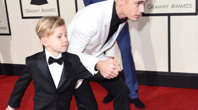 Penyanyi Justin Bieber dan adiknya, Jaxon, berjalan di karpet merah Grammy Awards 2016 di Staples Center, Los Angeles, Senin (15/2). Mantan kekasih Selena Gomez itu tampil kompak dengan sang adik yang juga mengenakan setelan jas. (AFP PHOTO/VALERIE MACON)