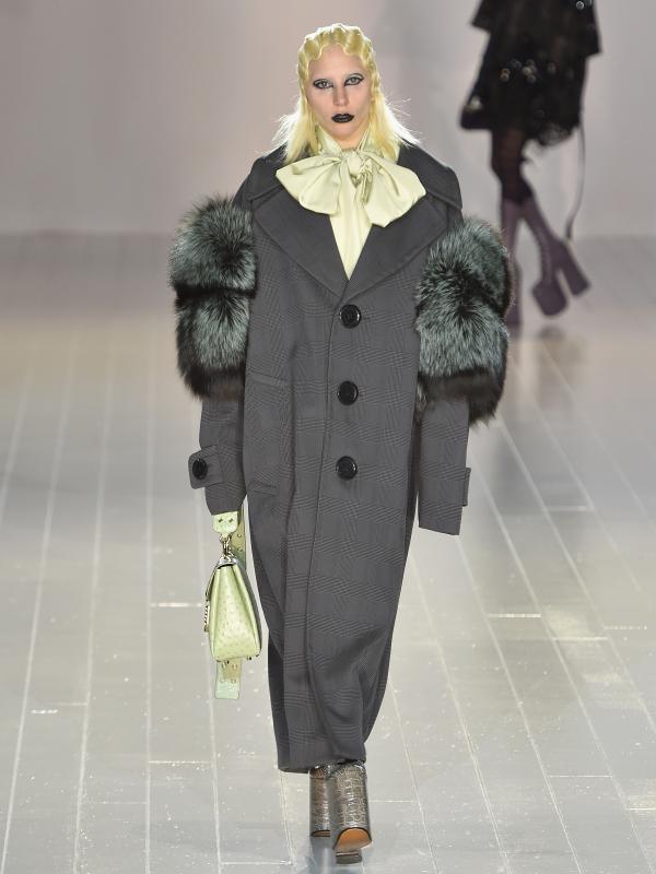 Lady Gaga tampil dengan oversize coat sambil menenteng tas saat menjadi model untuk Marc Jacobs pada acara New York Fashion Week, Kamis (18/2). Gaga tampil dengan eyeliner dan lipstik hitam. (Slaven VLASIC/Getty IMAGES NORTH AMERICA/AFP)