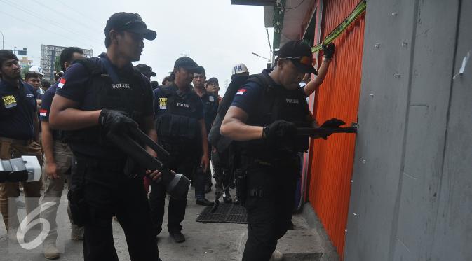 Petugas polisi membuka salah satu kafe dalam operasi Pekat di Kalijodo, Jakarta Utara, Sabtu (20/2). Operasi ini untuk menangani penyakit masyarakat di kawasan yang terkenal dengan prostitusi dan perjudian tersebut. (Liputan6.com/Faizal Fanani)