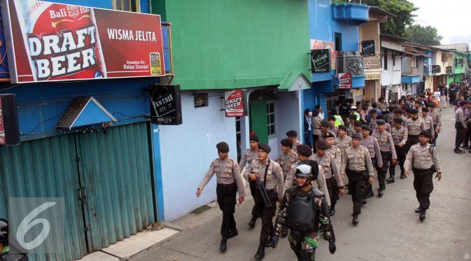 Petugas kepolisian saat melakukan operasi Pekat di kawasan Kalijodo, Jakarta Utara, Sabtu (20/2). Operasi ini bukanlah dalam rangka penggusuran yang direncanakan oleh Pemprov DKI Jakarta. (Liputan6.com/Faizal Fanani)