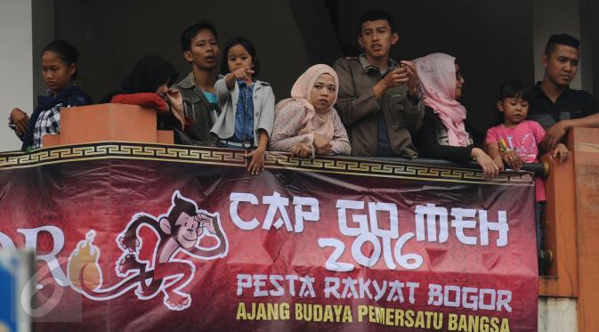Warga memadati salah satu gedung di sekitar Jalan Surya Kencana, Bogor untuk menyaksikan parade Pesta Rakyat Bogor dan perayaan Cap Go Meh, Senin (22/2/2016). Ribuan peserta mengikuti parade perayaan Cap Go Meh. (Liputan6.com/Helmi Fithriansyah)