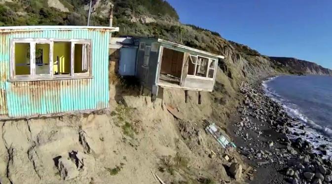 Sebuah rumah di tebing tepi laut di New Zealand perlahan-lahan runtuh karena tebingnya tergerus kekuatan alam. (Sumber video AOL)
