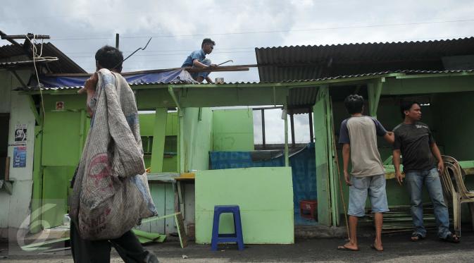 Sejumlah warga membongkar bangunan salah satu kafe di Kalijodo, Jakarta, Kamis (25/2). Pemerintah DKI melayangkan surat peringatan kedua (SP2) kepada warga untuk mengosongkan/membongkar sendiri bangunan mereka. (Lputan6.com/Gempur M Surya)