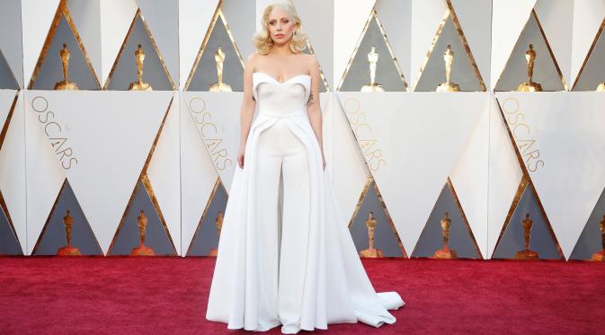 Penyanyi Lady Gaga tampil menyita perhatian pada red carpet Oscar 2016 dalam strapless white pantsuit dengan aksen rok flowing, di Hollywood & Highland Center, Hollywood, California, Minggu (28/2). (REUTERS/Lucy Nicholson)