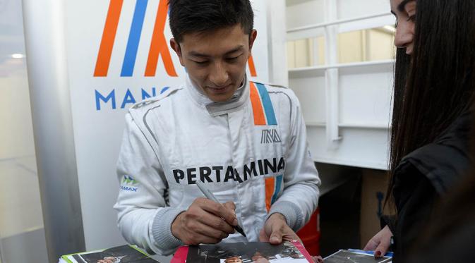Pebalap F1 asal Indonesia, Rio Haryanto, dengan penuh keramahan memberikan tanda tangan kepada fans usai jumpa pers di Sirkuit Catalunya, Spanyol. Pebalap asal tim Manor ini memang dikenal sebagai sosok yang ramah. (AFP/Josep Lago)