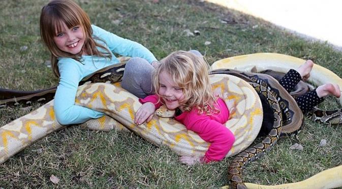 Erica dan Katie LeBlanc, anak-anak asal Kanada yang bergulung bersama ular. (Barcroft USA)