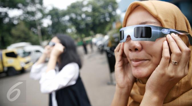 Petugas mencoba kacamata khusus yang akan digunakan saat pengamatan Gerhana Matahari Total (GMT) di Planetarium TIM Jakarta, Selasa (8/3). Planetarium akan memfasilitasi warga yang hendak menyaksikan fenomena gerhana matahari. (Liputan6.com/Faizal Fanani)