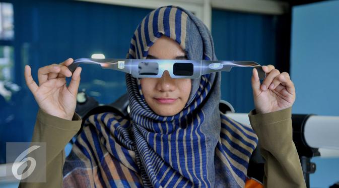 Petugas memperagakan kacamata untuk melihat gerhana matahari di Planetarium dan Observatorium, Taman Ismail Marzuki, Jakarta, Selasa (8/3). (/Gempur M Surya)