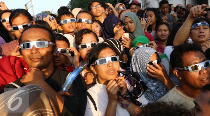 Sejumlah warga menyaksikan proses Gerhana Matahari Total (GMT) 2016 di halaman Taman Ismail Marzuki (TIM), Jakarta, Rabu (9/3). Fenomena gerhana matahari 90% bisa diamati selama 2,11 menit. (Liputan6.com/Fery Pradolo)