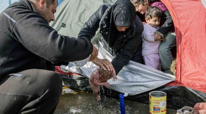 Jadi Imigran, Ibu Ini Mandikan Bayinya dengan Air Kubangan | via: thesun.co.uk