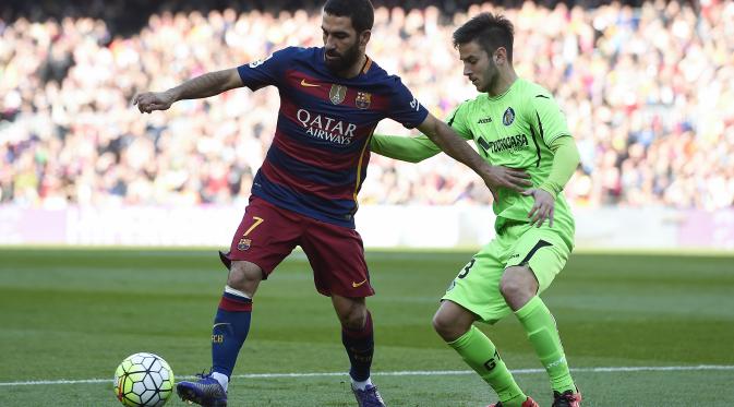 Arda Turan coba hindari terjangan dari pemain Getafe (Josep Lago/AFP)