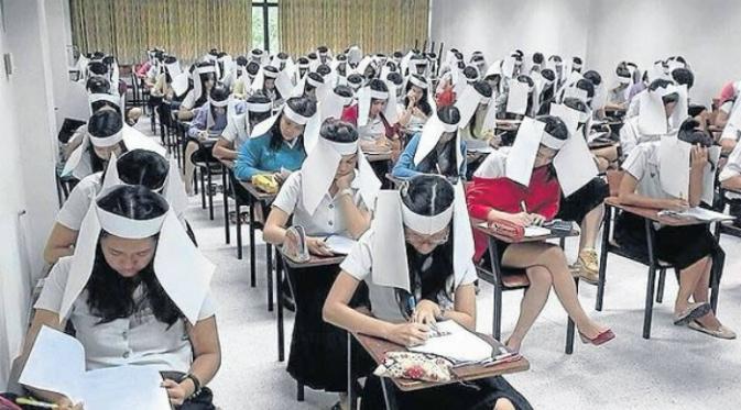 Untuk mencegah para siswanya berbuat curang saat ujian, para guru di Kasetsart University di Thailand membuat murid-muridnya seperti memakai penutup mata kuda yang terbuat dari kertas. (Oddee.com)