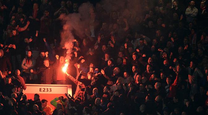 Para supporter Liverpool menyalakan suar saat klubnya bertandang ke markas MU pada laga leg kedua babak 16 Liga Europa di Stadion Old Trafford, Inggris, Jumat (18/3/2016) dini hari WIB. (AFP/Oli Scarff).