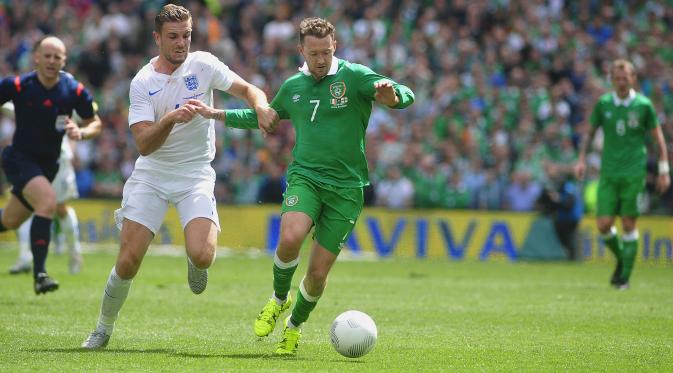 Gelandang Timnas Irlandia, Aiden McGeady (nomor 7) berjibaku dengan pemain Inggris, Jordan Henderson, pada laga persahabatan internasional, di Dublin (7/6/2015). (AFP)