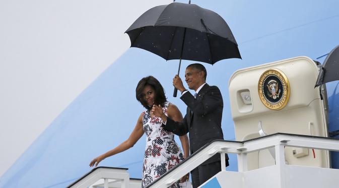 Presiden AS Barack Obama dan istrinya Michelle saat turun dari pesawat Air Force One setibanya di Bandara Internasional Havana, Kuba, Minggu (20/3). Kunjungan Obama ini yang pertama dilakukan seorang presiden AS sejak 88 tahun lalu. (REUTERS/stringer)