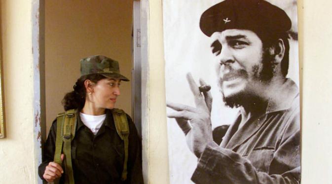 Seorang tentara perempuan terlihat berdiri di samping poster Che Guevara (Foto: Reuters).