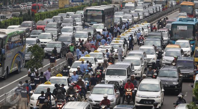Arus lalu lintas di sepanjang tol dalam kota dan Jalan Gatot Subroto, Jakarta, mengalami kemacetan parah, Selasa (22/3). Ribuan sopir taksi memblokir jalan protokol tersebut hingga membuat kendaraan lain tidak bisa lewat. (Liputan6.com/Immanuel Antonius)
