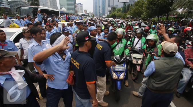 Ratusan pengendara Go-Jek terlibat kericuhan dengan sopir taksi di Jakarta, Selasa (22/3). Ratusan Go-Jek mendatangi para sopir taksi karena tersebar isu pemukulan terhadap beberapa pengendara Go-Jek oleh sopir taksi.  (Liputan6.com/Immanuel Antonius)