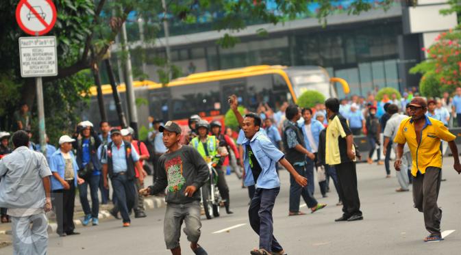 Aksi lempar batu antara sopir taksi yang melakukan unjuk rasa dan pengemudi ojek online terjadi di kawasan Sudirman, Jakarta, Selasa (22/3). Aksi itu pecah saat pengunjuk rasa mendapat perlawan dari pengemudi ojek online (Liputan6.com/Faisal R Syam)