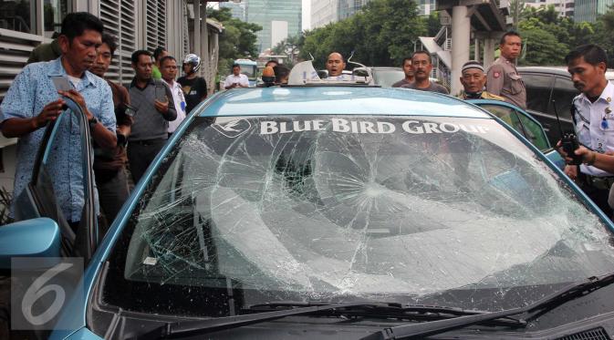 Sebuah taksi mengalami kerusakan usai diamuk massa di kawasan Kuningan, Jakarta, Selasa (22/3). Aksi anarkis ini adalah buntut dari demo yang dilakukan sejumlah sopir taksi. (Liputan6.com/Helmi Afandi)