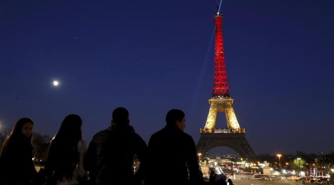 Menara Eiffel di Paris, Prancis, disinari dengan warna bendera Belgia (hitam, kuning, dan merah), Selasa (22/3). Hal itu sebagai bentuk penghormatan terhadap korban serangan bom Brussels. (REUTERS/Philippe Wojazer)