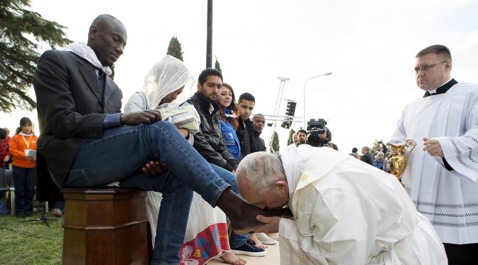 Paus Fransiskus mencium kaki imigran sebelum memimpin misa Kamis Putih, di sebuah lokasi penampungan di Castelnuovo, dekat Roma, Italia, Kamis (24/3/2016). (Reuters/ Osservatore Romano)