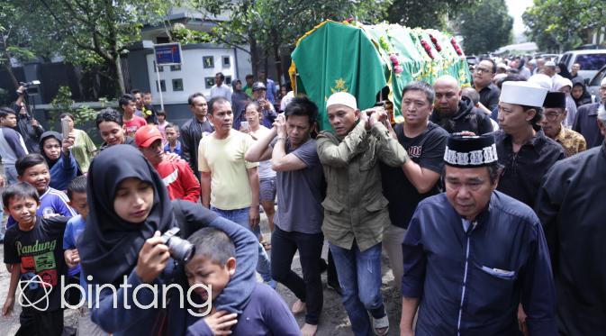 Dengan mengenakan kaos berwarna abu-abu, tanpa mengenakan alas kaki, Ariel ikut mengangkat keranda jenazah ayahnya menuju masjid. (Adrian Putra/Bintang.com)