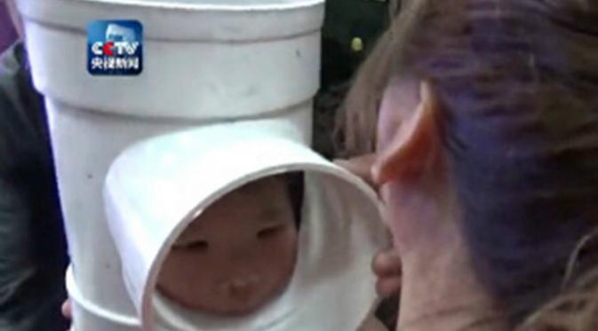Kepala bocah 5 tahun ini tersangkut pipa. (via: shanghaiist.com)