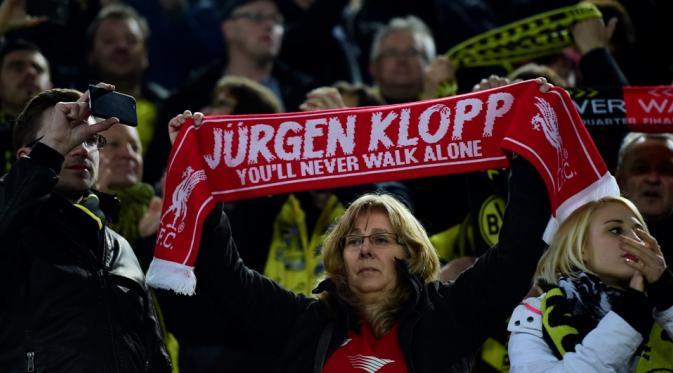Fans Liverpool dan Borussia Dortmund membentangkan syal yang bertuliskan Jurgen Klopp You'll Never Walk Alone, pada pertandingan leg pertama Liga Europa, di Stadion Signal Iduna Park, Jumat (8/4/2016) dini hari WIB. (AFP/John Macdougall).