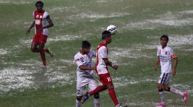 Para pemain Bali United dan PSM Makasar berebut bola diatas lapangan yang tergenang air  pada laga Trofeo Persija di Stadion Utama Gelora Bung Karno, Jakarta, Sabtu (9/4/2016). (Bola.com/Nicklas Hanoatubun)