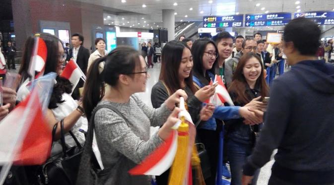 Pebalap Indonesia, Rio Haryanto, menyalami fans yang menyambutnya di Bandara Internasional Pudong Shanghai menjelang F1 GP China, Selasa (12/4/2016). (Bola.com/Media Relations Rio Haryanto)