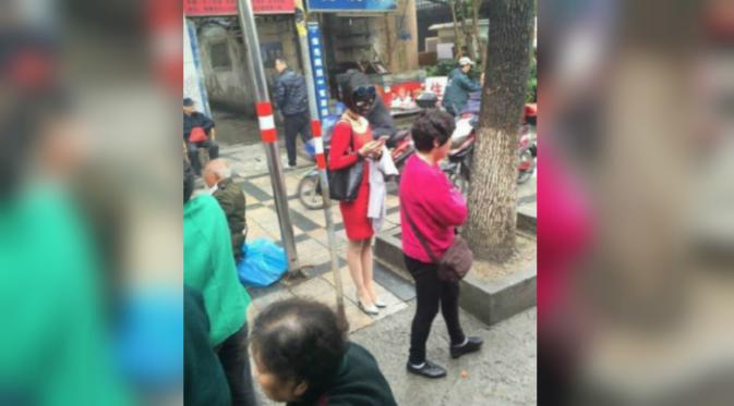 Tak hanya di kereta, wanita tersebut juga masih mengenakan maskernya ketika berada di pinggr jalan (Foto: weibo.com/1818hjy).