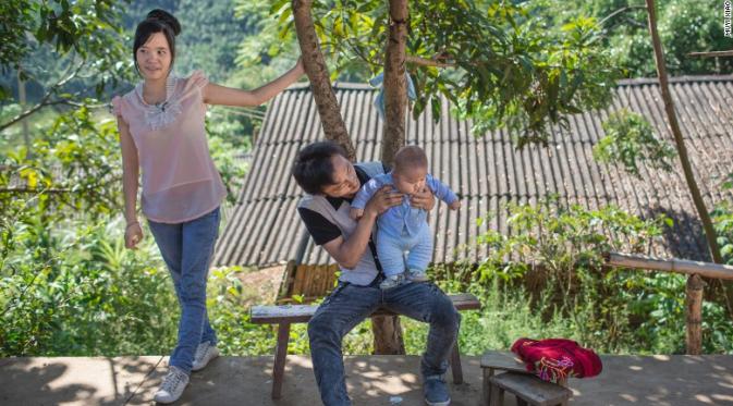 Xiao Rong, 16 tahun dan suaminya tengah menggendong bayi mereka berusia 10 bulan (Muyi Xiao)