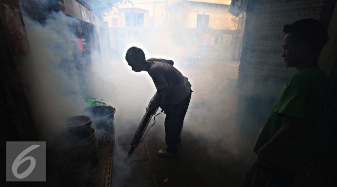 Petugas melakukan fogging di kawasan padat penduduk di Kebon Nanas, Jakarta, Jumat (15/4). Fogging tersebut dilakukan untuk mencegah berkembangbiaknya nyamuk aedes aegypti penyebab penyakit demam berdarah dengue. (Liputan6.com/Immanuel Antonius)