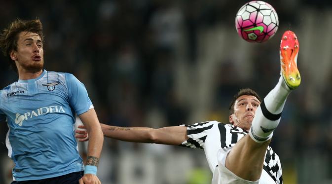 Striker Juventus, Mario Mandzukic (kanan), menghadapi Lazio pada laga Liga Italia musim lalu. (AFP/Marco Bertorello)