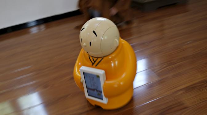 Robot Xian'er bergerak saat mendapat perintah pada demonstrasi di Vihara Longquan di Beijing, Tiongkok, 20 April 2016. Robot bhiksu itu mampu melakukan percakapan dengan orang-orang dan memahami instruksi serta mengikuti perintah. (REUTERS/Kim Kyung-Hoon)