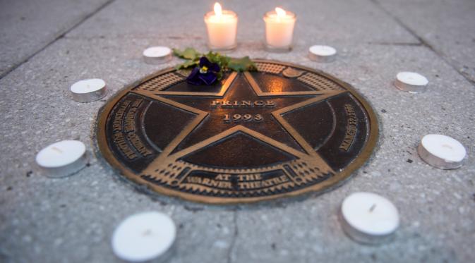 Lilin diletakkan di bintang Walk of Fame milik musisi legendaris, Prince di luar Teater Warner, Washington DC, Kamis (21/4). Pemilik nama lengkap Prince Rogers Nelson itu meninggal dunia di kediamannya pada usia 57 tahun. (Andrew Caballero-Reynolds/AFP)