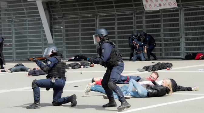 Petugas terlibat baku tembak saat melindungi warga sipil dalam latihan serangan teroris di Stadion Pierre Mauroy, Prancis (21/4). Latihan untuk mengantisipasi serangan teroris pada pertandingan sepak bola Euro 2016. (AFP PHOTO/DENIS Charlet).