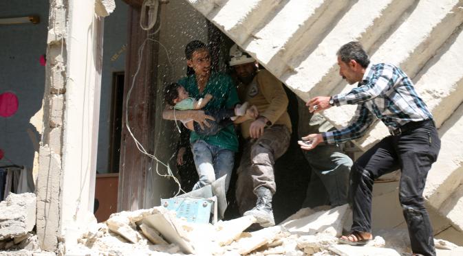 Relawan berusaha mengevakuasi bayi dari sebuah bangunan runtuh setelah serangan udara di wilayah yang dikuasai pemberontak al-Kalasa di kota Suriah bagian utara, Aleppo, Kamis (28/4). (AFP PHOTO / Ameer ALHALBI)