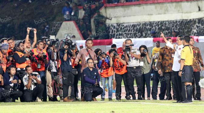 Presiden Joko Widodo, meniup pluit membuka babak kedua antara Persipura melawan Persija pada laga Torabika Soccer Championship 2016 di Stadion Mandala, Jayapura, Jumat (29/4/2016). (Bola.com/Nicklas Hanoatubun)